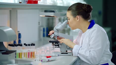 Scientist-with-microscope-in-lab.-Woman-scientist-doing-microscope-research
